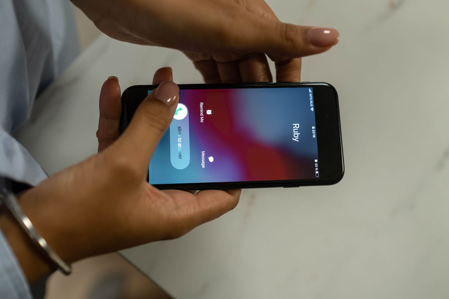 An incoming call ringing on a phone held in two hands