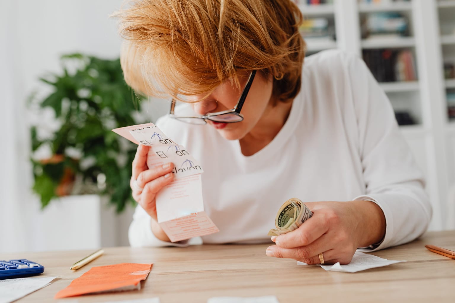How much an AI receptionist costs: a business owner reading the small print on a bill at her desk