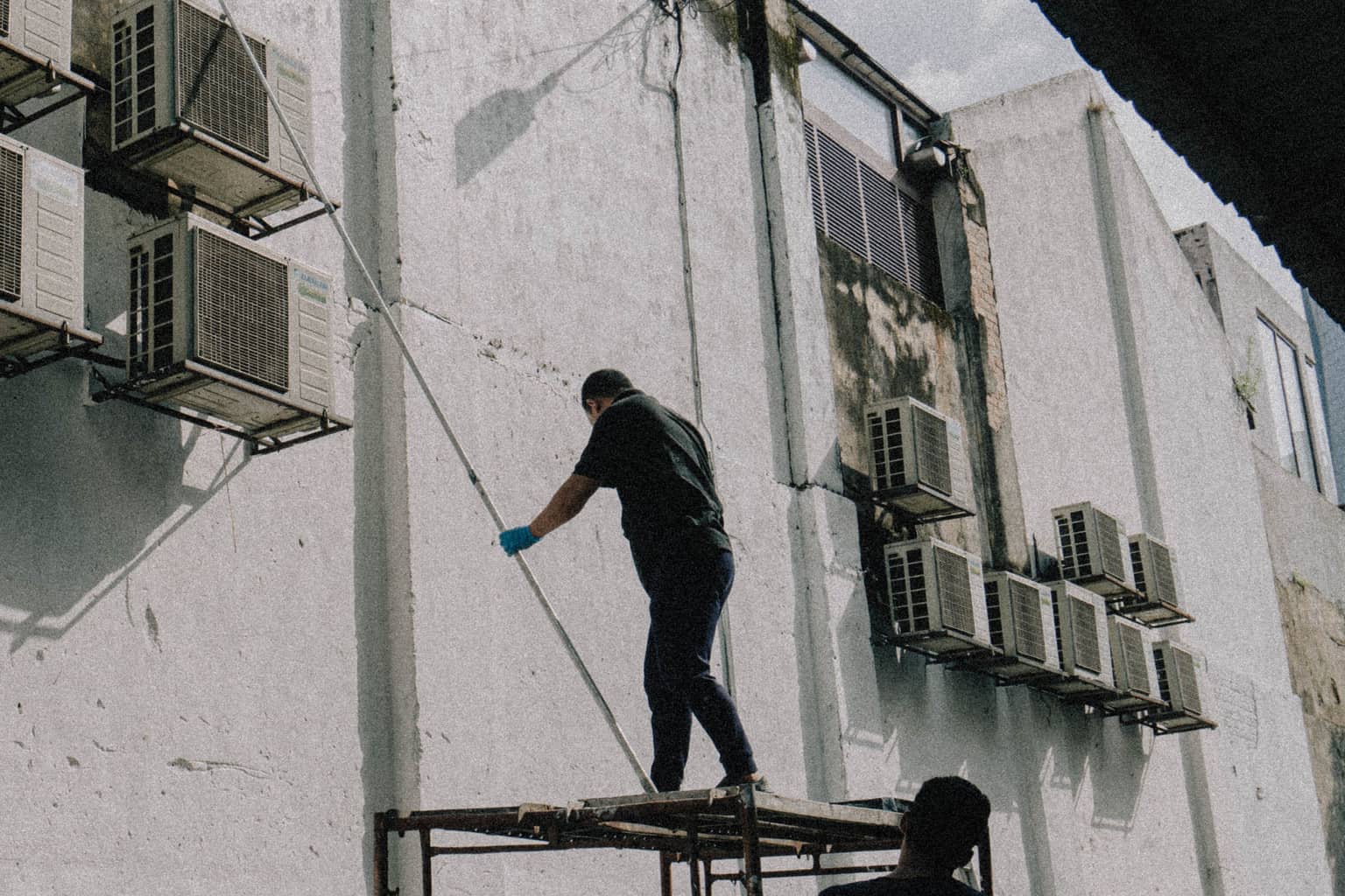 HVAC missed calls: a technician on a scaffold working among wall-mounted air conditioning units