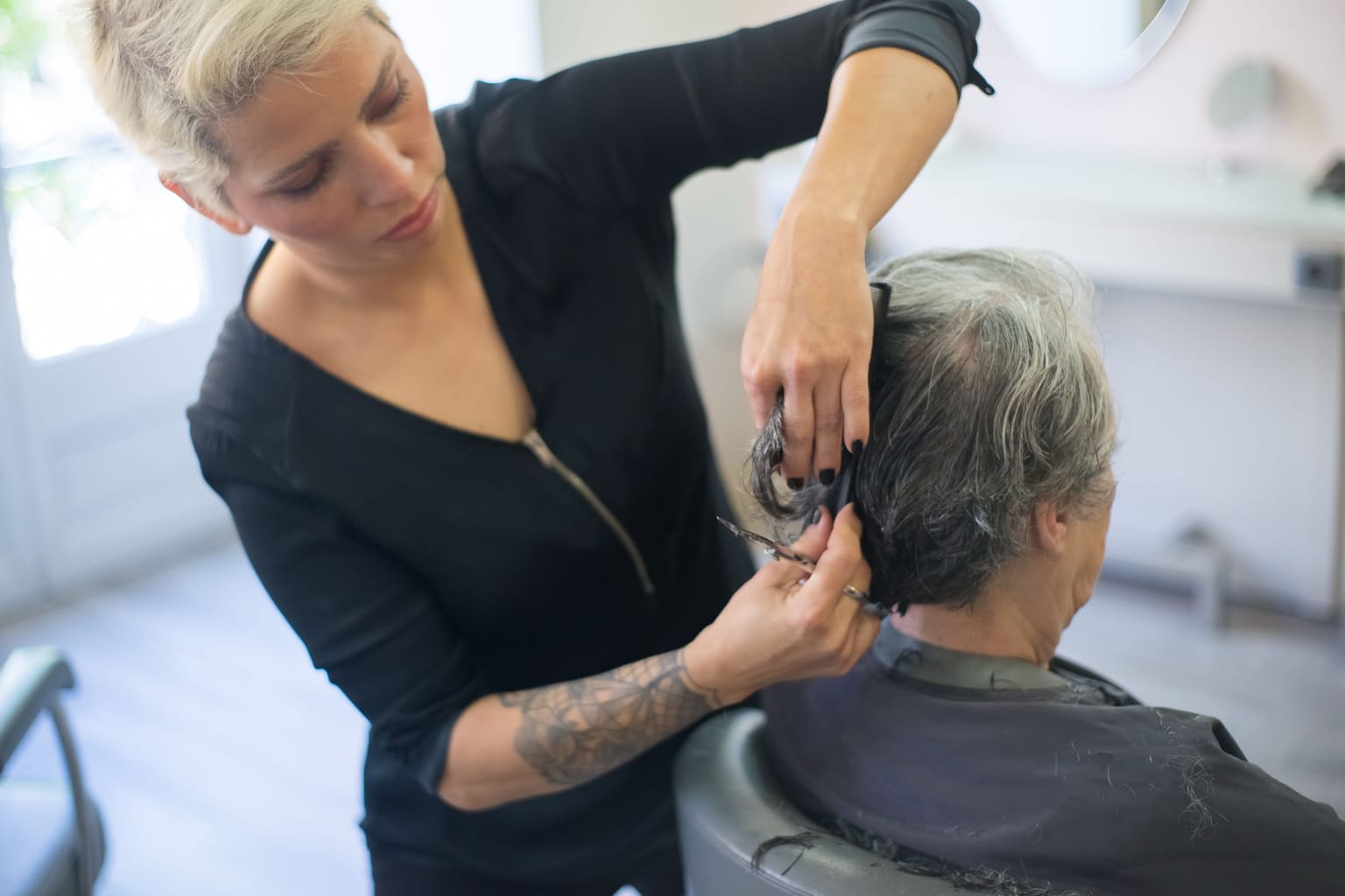 Salon missed calls: a stylist cutting a client's hair with both hands busy