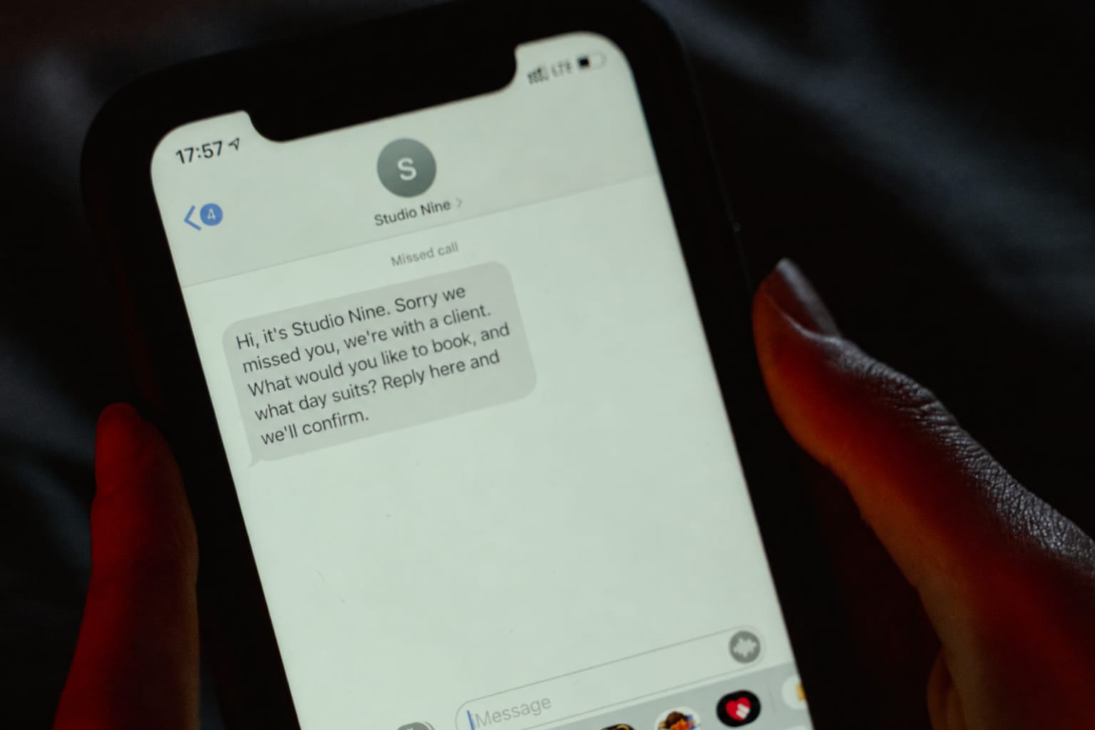 A phone showing a missed call followed by a text from the salon asking what the caller would like to book