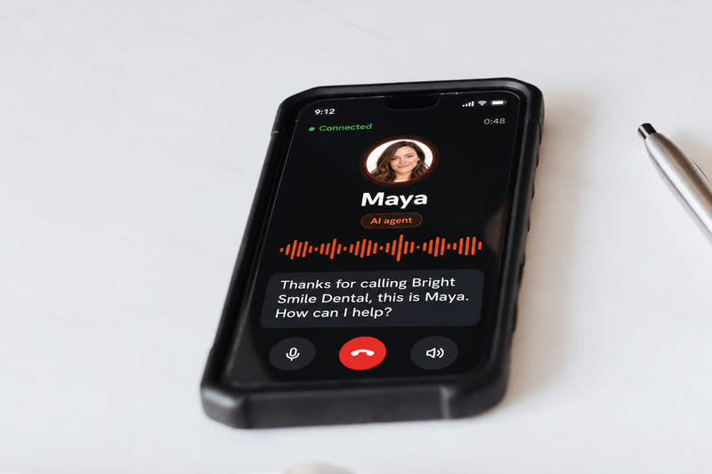 A phone on a desk on a live call with Maya, the AI agent, showing a voice waveform and her line: Thanks for calling Bright Smile Dental, this is Maya. How can I help?